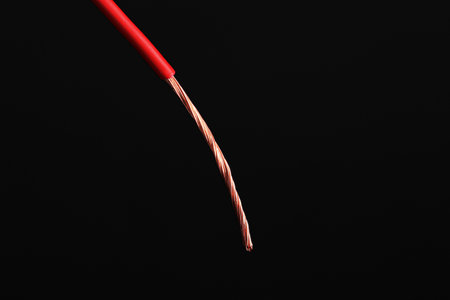 Red stripped electrical wire on black background, closeupの写真素材