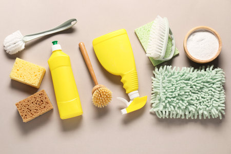 Different cleaning products, tools, cotton flowers and leaves on beige background, flat layの写真素材