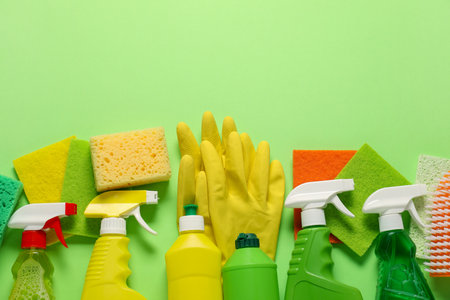 Different cleaning products in bottles and tools on green background, flat lay. Space for textの写真素材