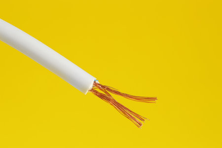 White stripped electrical wire on yellow background, closeupの写真素材
