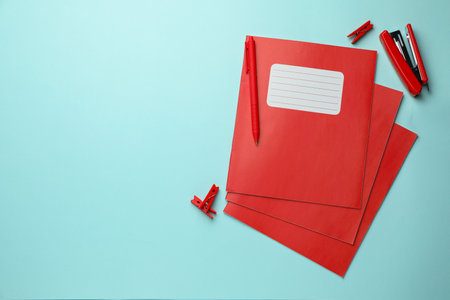 Copybooks and other school stationery on light blue background, flat lay. Space for textの写真素材