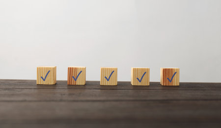 Wooden cubes with check marks on tableの写真素材