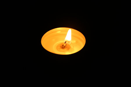 One burning candle in darkness, closeup viewの写真素材