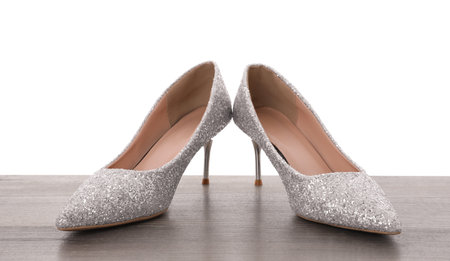 Beautiful high heeled shoes on wooden table against white backgroundの写真素材