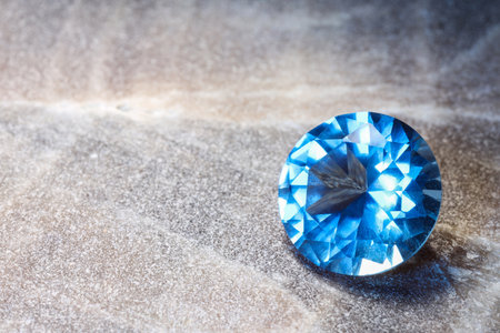 Beautiful shiny light blue gemstone on stone, space for textの写真素材