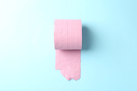 Pink toilet paper roll on light blue background, top viewの写真素材