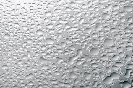Water drops on light gray glass surface, top viewの写真素材