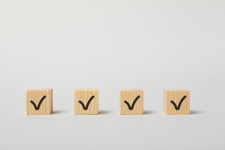 Wooden cubes with check marks on white background