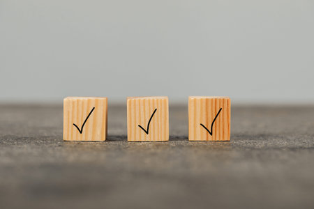 Wooden cubes with check marks on gray table