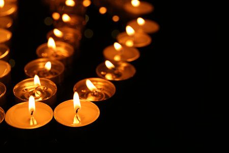 Many burning candles in darkness, closeup. Space for textの写真素材