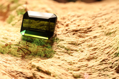Beautiful shiny green gemstone on stone, space for textの写真素材