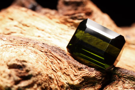 Beautiful shiny green gemstone on stone, closeup. Space for textの写真素材