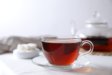 Refreshing black tea in cup on light table. Space for textの写真素材