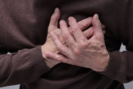 Heart attack. Senior man suffering from pain in chest, closeup