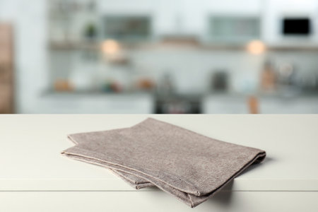 Folded tablecloth on wooden surface in kitchenの写真素材