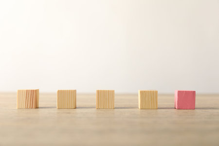 Many wooden cubes and pink one on table
