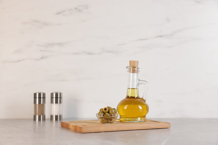 Bottle of oil, salt, pepper and olives on light gray tableの写真素材