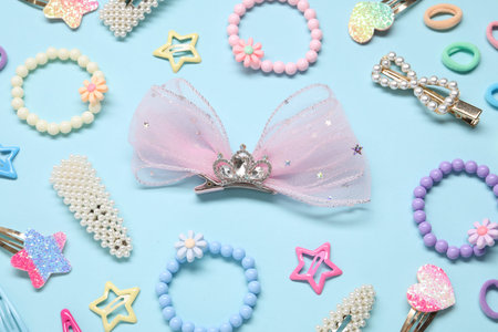 Cute hair accessories on light blue background, flat lay