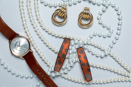 Flat lay composition with jewelry and watch on light grey background