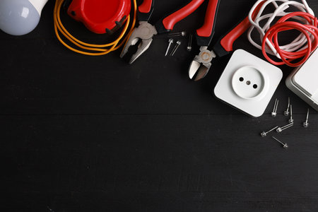 Different electrical tools on black wooden table, flat lay. Space for textの写真素材