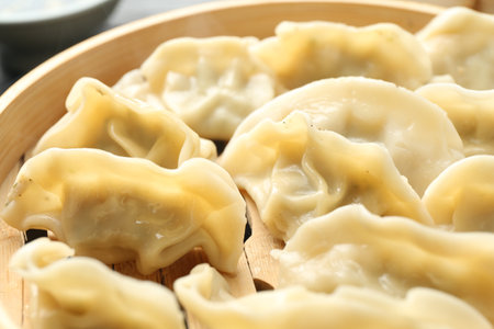 Tasty boiled gyoza (dumplings) in bamboo steamer on table, closeupの写真素材