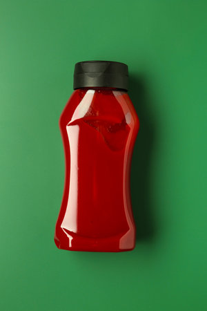 Bottle of ketchup on green background, top viewの写真素材