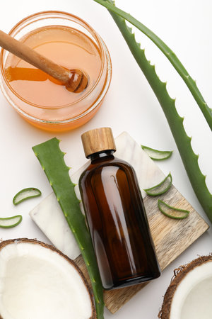 Hair treatment. Cosmetic product, coconut, honey and aloe leaves on white background, flat layの写真素材