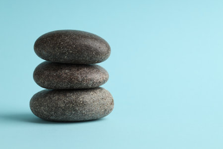 Stack of rocks on light blue background, space for text. Harmony and life balanceの写真素材