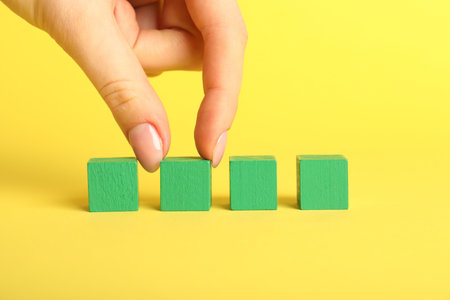 Green cubes on yellow background, closeup
