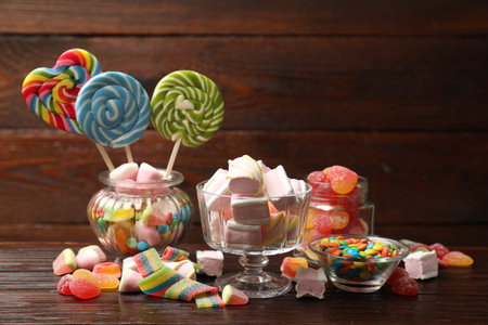 Many different tasty candies on wooden tableの写真素材