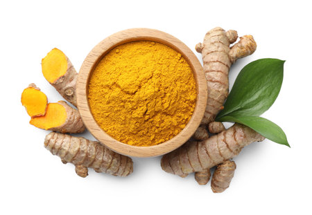 Turmeric powder in bowl, roots and green leaves isolated on white, top viewの写真素材