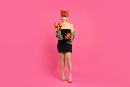 Quadrobics. Woman wearing fox mask and gloves on pink backgroundの写真素材