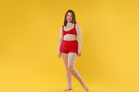 Woman in red underwear on orange background.の写真素材
