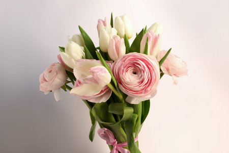 Bouquet of beautiful ranunculus and tulip flowers on white background, closeup