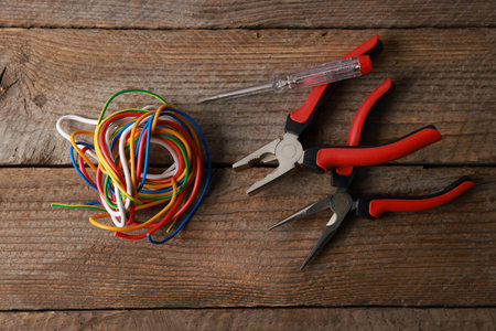 Different electrical tools on wooden table, flat lay