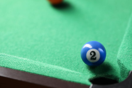 Billiard ball on green table, closeup. Space for text