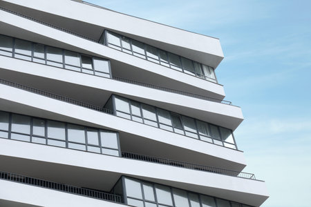 Modern building with many windows against blue sky, low angle view