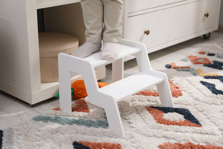 Little boy standing on step stool at home, closeupの写真素材