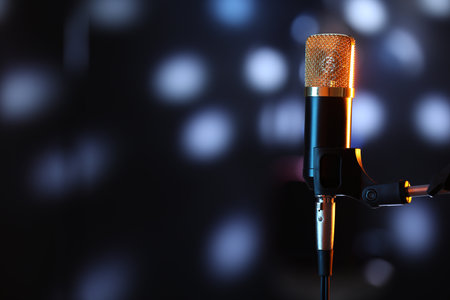 Microphone on stand against dark background with blurred lights, space for text. Bokeh effectの写真素材