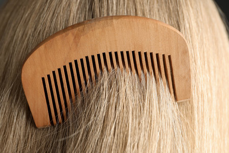 Brushing hair with wooden comb, closeup viewの写真素材