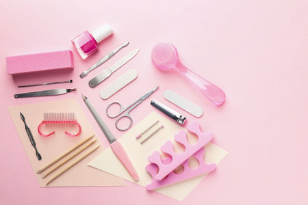 Set of pedicure tools on pink background, flat layの写真素材