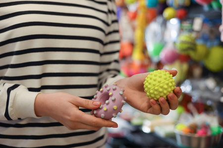 Woman with rubber toys in pet shop, closeupの写真素材