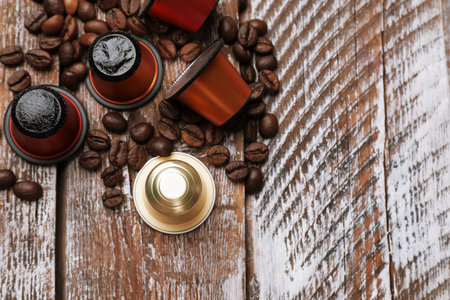 Coffee capsules and beans on wooden table, flat lay. Space for textの写真素材
