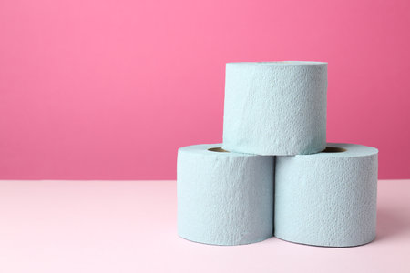 Blue toilet paper rolls on pink background. Space for textの写真素材