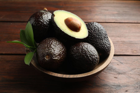 Fresh ripe avocados and leaves on wooden table, closeupの写真素材