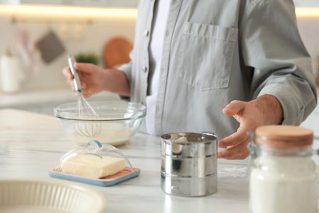 Man making dough at white marble table in kitchen, closeup