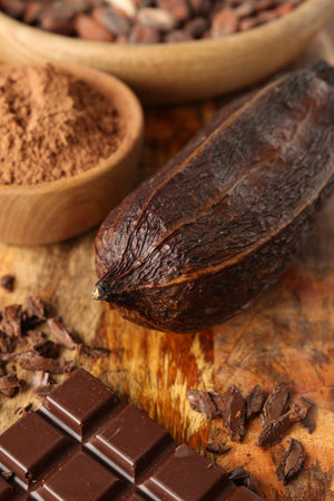 Cocoa pod, beans, powder and chocolate on wooden table, closeupの写真素材