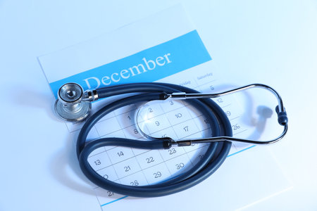 Stethoscope and calendar on light background, above viewの写真素材