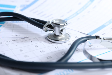 Stethoscope, calendar and medical card forms on table, closeupの写真素材