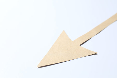 One kraft paper arrow on white background, closeup. Space for text